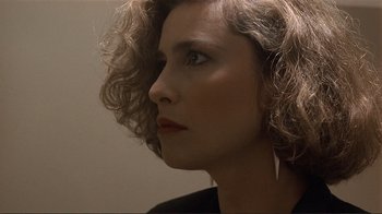 Movie still from “Someone to Watch Over Me” (1987), directed by Ridley Scott – A person with curly brown hair; Close Up shot, Over the shoulder angle