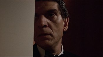 Movie still from “Someone to Watch Over Me” (1987), directed by Ridley Scott – A person wearing a suit and tie; Close Up shot, Low angle