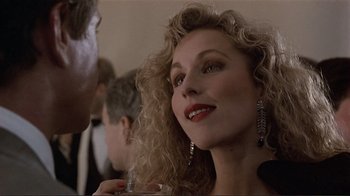 Movie still from “Someone to Watch Over Me” (1987), directed by Ridley Scott – A person with curly blonde hair; Close Up shot, Over the shoulder angle