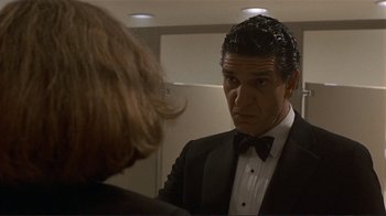 Movie still from “Someone to Watch Over Me” (1987), directed by Ridley Scott – A man in a tuxedo looking in the mirror; Close Up shot, Low angle