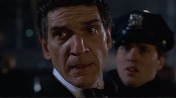 Movie still from “Someone to Watch Over Me” (1987), directed by Ridley Scott – A man that is looking at the camera; Close Up shot, Low angle