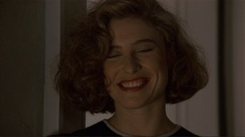 Movie still from “Someone to Watch Over Me” (1987), directed by Ridley Scott – A person smiling with her eyes closed; Close Up shot, Over the shoulder angle