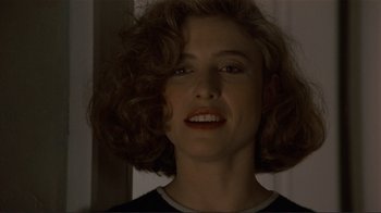 Movie still from “Someone to Watch Over Me” (1987), directed by Ridley Scott – A person with curly brown hair; Close Up shot, Over the shoulder angle