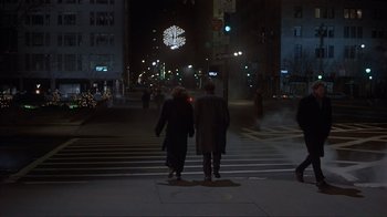 Movie still from “Someone to Watch Over Me” (1987), directed by Ridley Scott – Two people are walking down a street at night; Wide shot, Over the shoulder angle