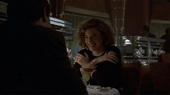 Movie still from “Someone to Watch Over Me” (1987), directed by Ridley Scott – A woman sitting in front of a man at a table; Medium shot, Over the shoulder angle