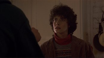 Movie still from “Someone to Watch Over Me” (1987), directed by Ridley Scott – A woman with curly hair wearing a red scarf; Close Up shot, Over the shoulder angle