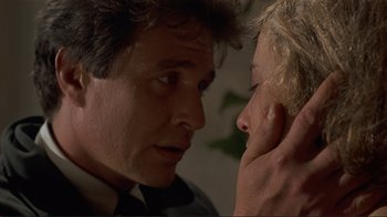 Movie still from “Someone to Watch Over Me” (1987), directed by Ridley Scott – A person touching a persons ear; Close Up shot, Low angle