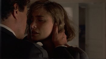 Movie still from “Someone to Watch Over Me” (1987), directed by Ridley Scott – A man touching the ear of a young woman; Close Up shot, Over the shoulder angle