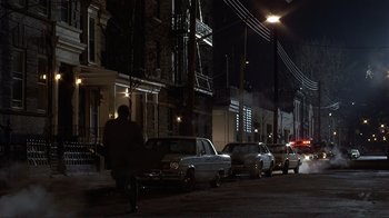 Movie still from “Someone to Watch Over Me” (1987), directed by Ridley Scott – A man walking down a street at night; Extreme Wide shot, High angle