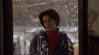 Movie still from “Someone to Watch Over Me” (1987), directed by Ridley Scott – A woman standing in front of an umbrella; Close Up shot, Low angle