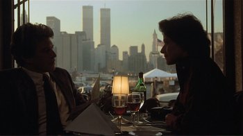Movie still from “Someone to Watch Over Me” (1987), directed by Ridley Scott – Two people are sitting at a table with wine glasses; Medium shot, Over the shoulder angle