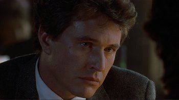 Movie still from “Someone to Watch Over Me” (1987), directed by Ridley Scott – A person wearing a suit and tie; Close Up shot, Low angle