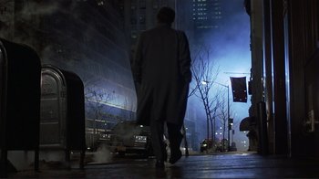 Movie still from “Someone to Watch Over Me” (1987), directed by Ridley Scott – A man walking down the street at night in the dark; Wide shot, Low angle