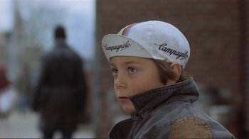 Movie still from “Someone to Watch Over Me” (1987), directed by Ridley Scott – A young boy wearing a white cap and jacket; Close Up shot, Over the shoulder angle