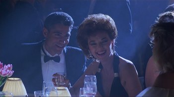 Movie still from “Someone to Watch Over Me” (1987), directed by Ridley Scott – A man and a woman sitting at a dinner table; Medium shot, Low angle