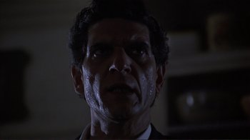 Movie still from “Someone to Watch Over Me” (1987), directed by Ridley Scott – A person wearing a suit and tie; Close Up shot, Low angle