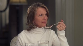 Movie still from “Something's Gotta Give” (2003), directed by Nancy Meyers – A woman in a white sweater holding a fork in front of her face; Close Up shot, Over the shoulder angle
