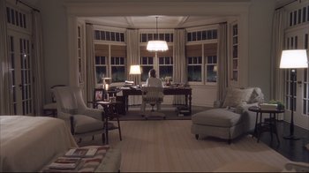 Movie still from “Something's Gotta Give” (2003), directed by Nancy Meyers – A woman sitting at a desk in a room with large windows; Wide shot, High angle