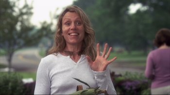 Movie still from “Something's Gotta Give” (2003), directed by Nancy Meyers – A woman with long hair is smiling and holding a plant; Medium shot, Low angle