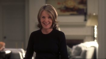 Movie still from “Something's Gotta Give” (2003), directed by Nancy Meyers – A woman in a black shirt smiling for the camera; Medium shot, Over the shoulder angle