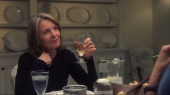 Movie still from “Something's Gotta Give” (2003), directed by Nancy Meyers – A woman sitting at a table holding a glass of wine; Close Up shot, Over the shoulder angle