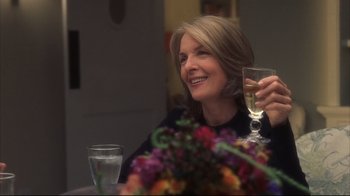 Movie still from “Something's Gotta Give” (2003), directed by Nancy Meyers – A woman sitting at a table holding a wine glass; Close Up shot, Over the shoulder angle
