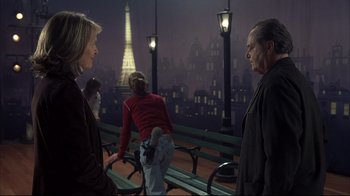 Movie still from “Something's Gotta Give” (2003), directed by Nancy Meyers – Two women and an older man are standing on a bench in front of the eiffel tower at night; Medium shot, Over the shoulder angle