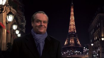 Movie still from “Something's Gotta Give” (2003), directed by Nancy Meyers – A man in a suit and a scarf standing in front of the eiffel tower at night; Medium shot, Low angle