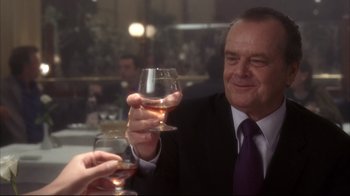Movie still from “Something's Gotta Give” (2003), directed by Nancy Meyers – A man in a suit and tie raising a glass of wine; Medium shot, Over the shoulder angle