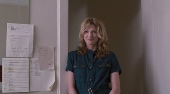 Movie still from “Somewhere” (2010), directed by Sofia Coppola – A woman standing in front of a wall with her hands on her hips; Medium shot, Over the shoulder angle