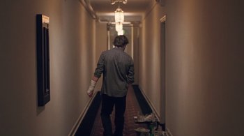 Movie still from “Somewhere” (2010), directed by Sofia Coppola – A man walking down a hallway with bandages on his hands; Wide shot, Low angle