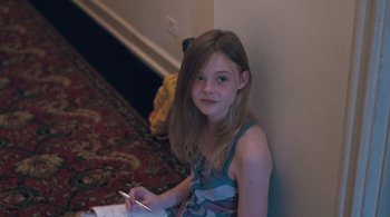 Movie still from “Somewhere” (2010), directed by Sofia Coppola – A young girl sitting on the ground writing; Medium shot, High angle