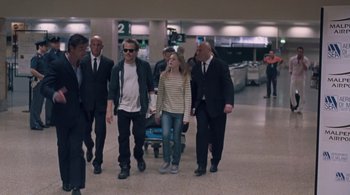 Movie still from “Somewhere” (2010), directed by Sofia Coppola – A group of people walking in an airport terminal; Wide shot, Low angle