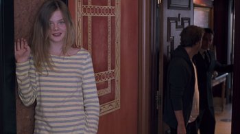 Movie still from “Somewhere” (2010), directed by Sofia Coppola – A young woman standing in front of a doorway; Medium shot, Over the shoulder angle