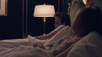 Movie still from “Somewhere” (2010), directed by Sofia Coppola – A man and a woman in a bed with a lamp; Medium shot, High angle