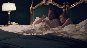 Movie still from “Somewhere” (2010), directed by Sofia Coppola – A man and a woman laying in a bed together; Medium shot, High angle