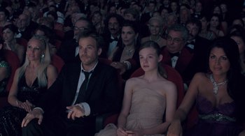 Movie still from “Somewhere” (2010), directed by Sofia Coppola – A group of people sitting together in a theater; Medium shot, High angle