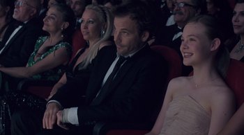 Movie still from “Somewhere” (2010), directed by Sofia Coppola – A group of people sitting in a row at an event; Medium shot, High angle