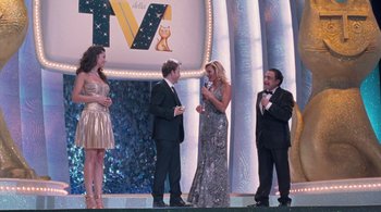 Movie still from “Somewhere” (2010), directed by Sofia Coppola – A group of people standing on a stage talking to each other; Wide shot, Over the shoulder angle