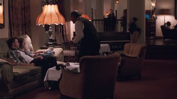 Movie still from “Somewhere” (2010), directed by Sofia Coppola – An old man in a suit is standing in a room; Wide shot, High angle
