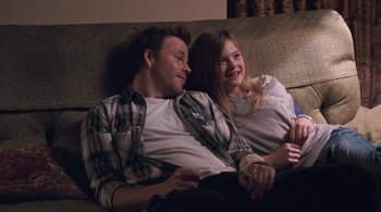 Movie still from “Somewhere” (2010), directed by Sofia Coppola – A man and a woman sitting on a couch together; Medium shot, Over the shoulder angle