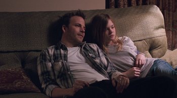 Movie still from “Somewhere” (2010), directed by Sofia Coppola – A man and a woman sitting on a couch together; Medium shot, Over the shoulder angle