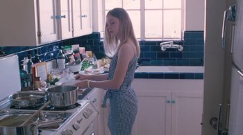 Movie still from “Somewhere” (2010), directed by Sofia Coppola – A woman standing in front of a stove preparing food; Medium shot, High angle