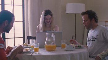 Movie still from “Somewhere” (2010), directed by Sofia Coppola – A woman sitting in front of a computer at a table; Medium shot, Over the shoulder angle