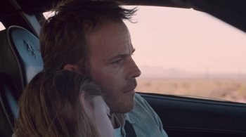 Movie still from “Somewhere” (2010), directed by Sofia Coppola – A man and a woman sitting in a car talking on a cell phone; Close Up shot, Over the shoulder angle