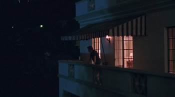 Movie still from “Somewhere” (2010), directed by Sofia Coppola – A person standing on a balcony at night; Wide shot, Low angle