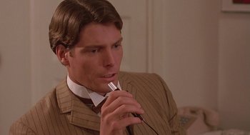 Movie still from “Somewhere in Time” (1980), directed by Jeannot Szwarc – A man wearing a suit and tie holding a pen; Close Up shot, Over the shoulder angle