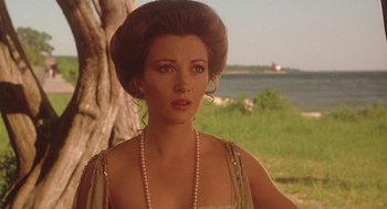 Movie still from “Somewhere in Time” (1980), directed by Jeannot Szwarc – A beautiful woman with long brown hair wearing pearls; Close Up shot, Over the shoulder angle