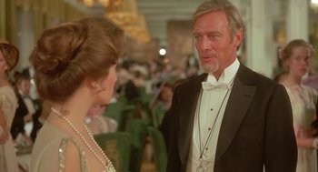 Movie still from “Somewhere in Time” (1980), directed by Jeannot Szwarc – An older man in a tuxedo talking to an older woman; Close Up shot, Over the shoulder angle