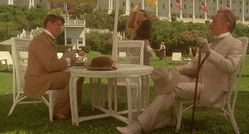 Movie still from “Somewhere in Time” (1980), directed by Jeannot Szwarc – A group of people sitting at a table in the grass; Wide shot, High angle